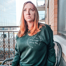 Load image into Gallery viewer, Woman with long blonde hair and green eyes sitting on a new York city apartment balcony looking up at the sky wearing a Green dog mom sweatshirt with white writing on top right chest area reads "i form calming circles with my dog" surrounded by two half circles of paws
