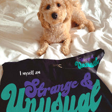 Load image into Gallery viewer, mini doodle dog lying on bed with matching beetlejuice inspired "Strange and unusual" dog mom t-shirt and dog bandana